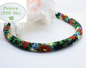 May include: A beaded necklace with a floral pattern in red, green, white, and blue. The necklace is black and has a round shape.