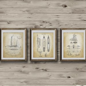 May include: Three framed vintage nautical prints of sailing ships. The prints are in black and white and have a distressed look. The frames are brown wood with a gold trim.