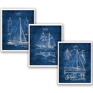 May include: Set of three vintage nautical blue and white patent drawings of sailboats. The drawings are in a distressed style and feature detailed illustrations of the boats.