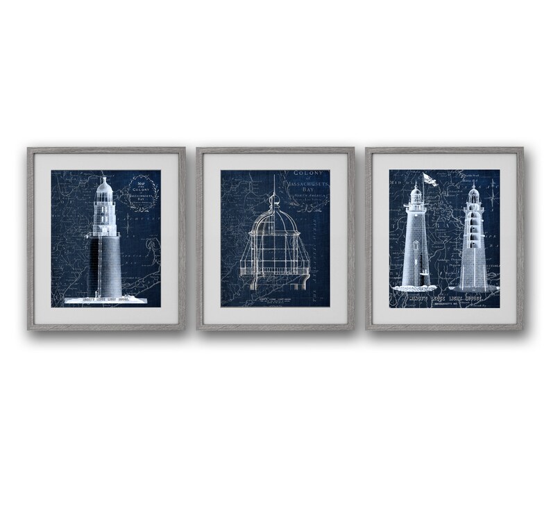 May include: Set of three framed prints featuring vintage nautical blueprints of lighthouses. The prints are in shades of blue and white and are framed in a simple grey frame.