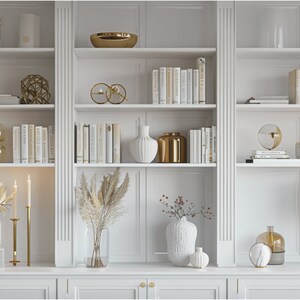 May include: White bookshelves with gold accents and decorative objects, including vases, candles, and books. The shelves are styled with dried pampas grass and other natural elements.