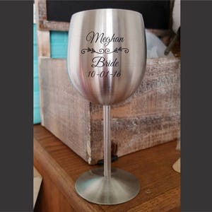 May include: A stainless steel wine glass with an engraved design. The glass has the text "Meghan Bride 10-01-16" on it.