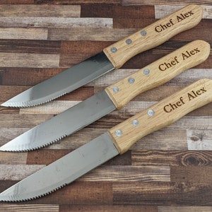 May include: Three stainless steel steak knives with wooden handles. Each handle is engraved with the text "Chef Alex".