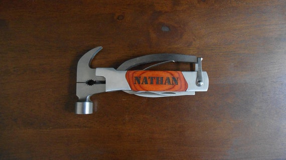A laser-engraved multi-tool built around a hammer — a genuinely useful and unexpectedly clever combo that makes a memorable groomsmen or dad gift.