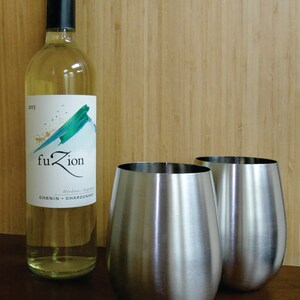 May include: Two stainless steel wine glasses and a bottle of white wine labeled "fuZion" with the text "Mendoza - Argentina" and "CHENIN - CHARDONNAY".