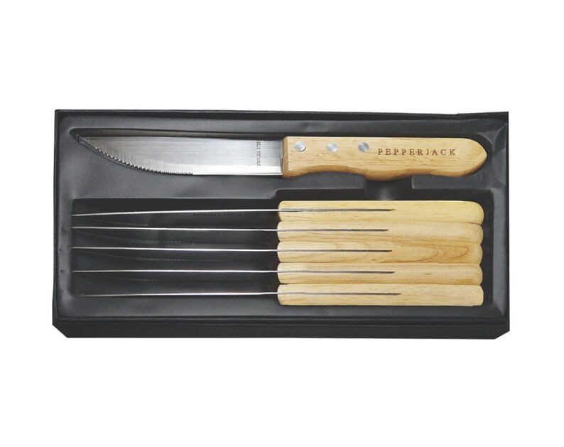 May include: A set of six steak knives with wooden handles in a black box. The knives have serrated blades and the handles are engraved with the word "Pepperjack".