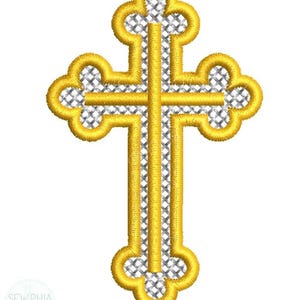 Puede incluir: Cruz dorada bordada con relleno de malla plateada. La cruz tiene un diseño decorativo y ornamentado con bordes redondeados. El texto "SEW PHIA Embroidery" está en la parte inferior izquierda.