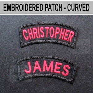 May include: Two black, curved embroidered patches with red lettering. The top patch reads "CHRISTOPHER" and the bottom patch reads "JAMES". The patches are bordered with black stitching and are set against a dark background. The text "EMBROIDERED PATCH - CURVED" is at the top.