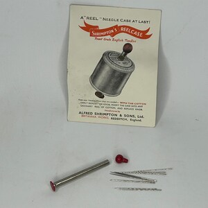 Puede incluir: Un estuche vintage para agujas con un carrete de metal que contiene agujas. El estuche est&aacute; etiquetado como "Shrimpton's Reelcase" y "Finest Grade English Needles". El estuche est&aacute; dise&ntilde;ado para adaptarse a un carrete de hilo est&aacute;ndar.