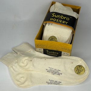 May include: A pair of off-white "Sunbro" hosiery socks, with another pair inside a yellow box with black and gold text. The socks are labeled "Plated Art Silk with Lastex Nylon Reinforced", made in England.