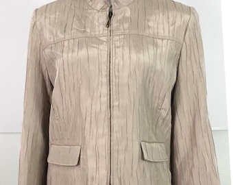 May include: A beige jacket with a stand-up collar and a front zipper closure. The jacket has two front pockets and a textured, vertical ribbed pattern. The sleeves are long, and the jacket is displayed on a white mannequin.