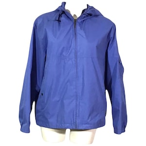 May include: A light blue hooded jacket with a zipper closure. The jacket has a drawstring hood and two pockets.