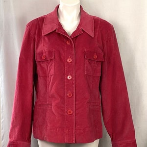 May include: A red corduroy jacket with a collared neckline, two chest pockets, and two lower pockets. The jacket has a button-up front and long sleeves. The jacket is displayed on a white mannequin.