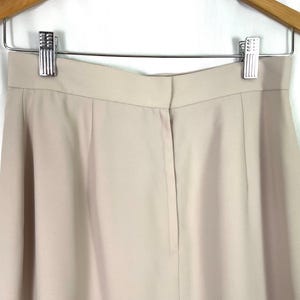 May include: A pair of beige high-waisted pants with a center back zipper and a straight leg.