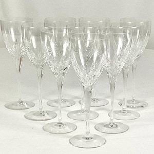May include: A collection of ten clear crystal wine glasses. Each glass features a slender stem and a bowl with a decorative, textured pattern. The glasses are arranged on a white surface, showcasing their elegant design.