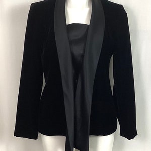 May include: A black velvet blazer with a satin shawl collar. The collar is tied at the front.