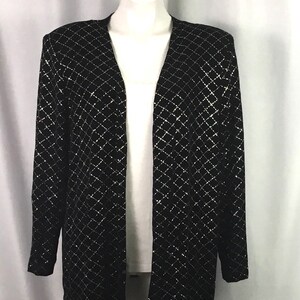 May include: A black long-sleeved cardigan with a silver diamond pattern. The cardigan has a V-neck and open front.