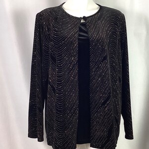 May include: Black velvet cardigan with a gold glitter pattern. The cardigan has a round neckline and a single button closure.
