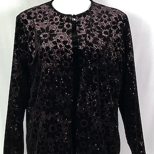 May include: Black velvet jacket with a floral lace pattern in a gradient of pink and black. The long-sleeved jacket has a round neckline and a single button closure. The jacket is displayed on a white mannequin.