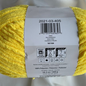 Puede incluir: Una madeja de hilo amarillo super bulky, de 10,5 onzas o 300 gramos, hecha de 100% poli&eacute;ster. La etiqueta incluye el nombre del hilo, "Pale Marigold", y el c&oacute;digo del producto, "2021-03-405".