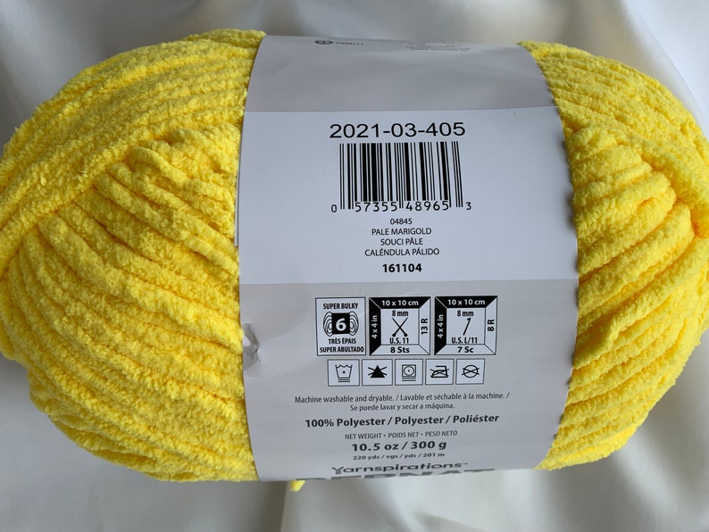 Puede incluir: Una madeja de hilo amarillo super bulky, de 10,5 onzas o 300 gramos, hecha de 100% poli&eacute;ster. La etiqueta incluye el nombre del hilo, "Pale Marigold", y el c&oacute;digo del producto, "2021-03-405".