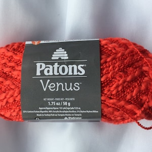 May include: A skein of Patons Venus yarn in a bright orange color. The label reads "Patons Venus" and "1.75 oz/50 g".