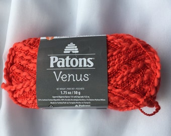 Puede incluir: Un ovillo de hilo Patons Venus de color naranja brillante. La etiqueta dice "Patons Venus" y "1.75 oz/50 g".