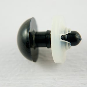 May include: A black plastic safety eye with a white plastic washer. The eye is designed for use in stuffed toys and other crafts.