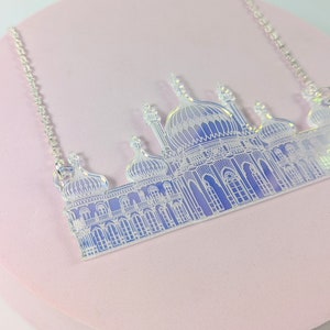 May include: A silver chain necklace with a white iridescent pendant shaped like the Brighton Pavilion, a famous landmark in Brighton, England.