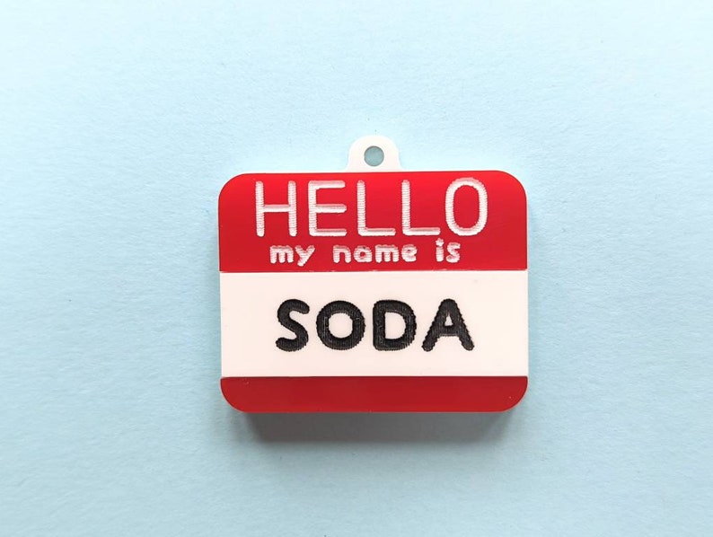 May include: Red and white name tag with the text "HELLO my name is SODA" printed in black.