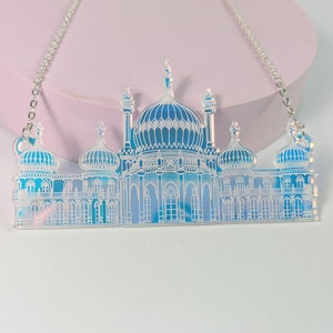 May include: A silver chain necklace with a blue and white iridescent pendant shaped like the Royal Pavilion in Brighton, England.