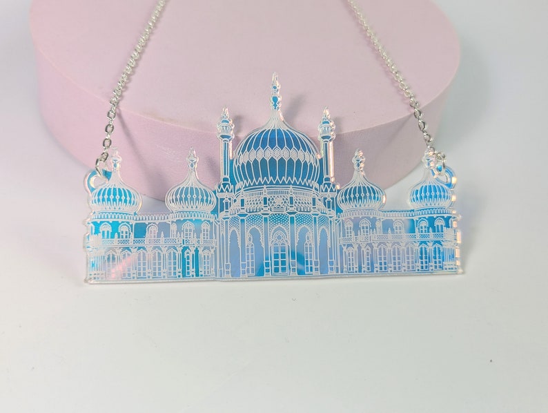 May include: A silver chain necklace with a blue and white iridescent pendant shaped like the Royal Pavilion in Brighton, England.