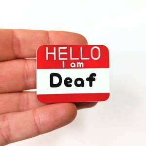 May include: A red name tag with white lettering that reads "HELLO I am Deaf".