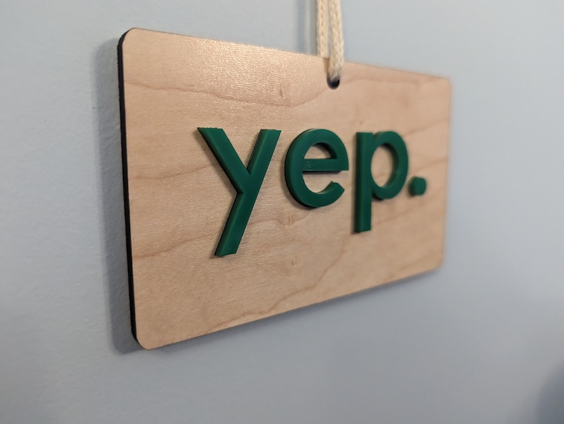 Puede incluir: Un letrero de madera con la palabra "yep" en letras verdes.