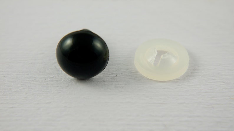 May include: A black plastic safety eye with a clear plastic washer. The eye is about 1 inch in diameter.