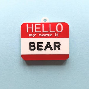 May include: Red and white name tag with the text "HELLO my name is BEAR" printed in white.