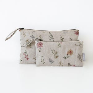 Nachhaltige Kosmetik-Accessoires. Minimalistisches Make-up-Täschchen aus Leinen mit Blumenmotiv.