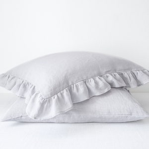Hellgrauer Leinen-Kissenbezug mit Rüschen. Leinen-Kissenbezug mit Rüschen. Bettwäsche aus Leinen mit Rüschen.