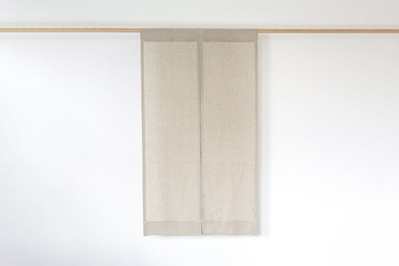May include: A pair of beige linen curtains hanging from a wooden rod.