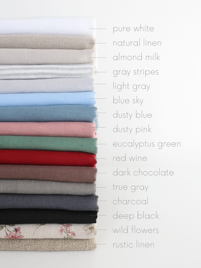 May include: A stack of folded fabric samples in various colors, including pure white, natural linen, and dusty pink. The samples are labeled with their respective color names, such as "blue sky" and "red wine."
