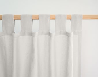 Könnte beinhalten: Hellgraue Leinen-Vorhänge mit Laschen-Detail, die an einer Naturholzstange hängen. Die Vorhänge bestehen aus einem weichen, strukturierten Stoff und hängen in sanften Falten. Die neutrale Farbe und das schlichte Design schaffen eine minimalistische Ästhetik.