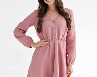 Vestido de lino rosa empolvado, escote en V, mangas abullonadas, tejido transpirable.