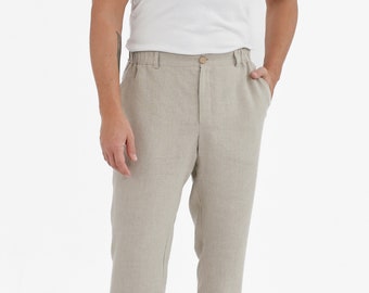 May include: Beige linen pants with a drawstring waist and a button fly. The pants have a relaxed fit and are made of a lightweight fabric.