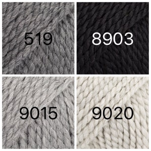 May include: Four skeins of yarn in different colors: gray, black, light gray, and white. The yarn is chunky and has a textured look. The skeins are labeled with the numbers 519, 8903, 9015, and 9020.