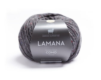 May include: A ball of gray yarn with red and blue flecks. The label reads "LAMANA COMO TWEED MERINO SUPERFINE 100% SCHURWOLLE/WOOL 50g - 120m"