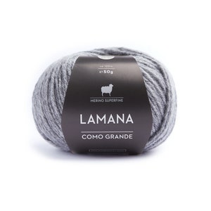 May include: A ball of gray yarn with a black label that reads "LAMANA COMO GRANDE" and "MERINO SUPERFINE". The label also includes a sheep illustration and the text "ca. 120 m e 50g".