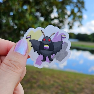 May include: A black and white cartoon moth with yellow and purple accents holding two small flags. The flags are yellow, white, and purple. The moth is wearing a black shirt with a yellow, white, and purple circle on it.