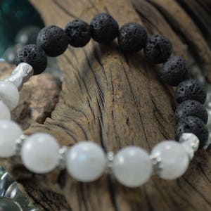May include: A black lava rock and white moonstone beaded bracelet. The bracelet is made with alternating black lava rock and white moonstone beads.