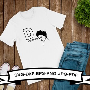 May include: White t-shirt with a black graphic of the letter D and a woman's face. The text "D is for Dorothy" is below the graphic. The text "SVG-DXF-EPS-PNG-JPG-PDF" is at the bottom of the shirt.