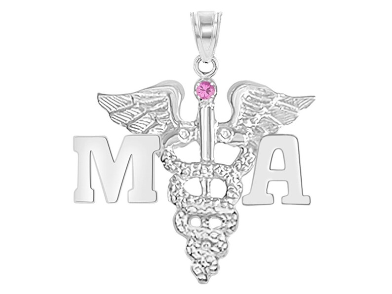 May include: Silver pendant necklace with a medical caduceus symbol and the letters "MA" on either side. The caduceus has a pink gemstone at the top.